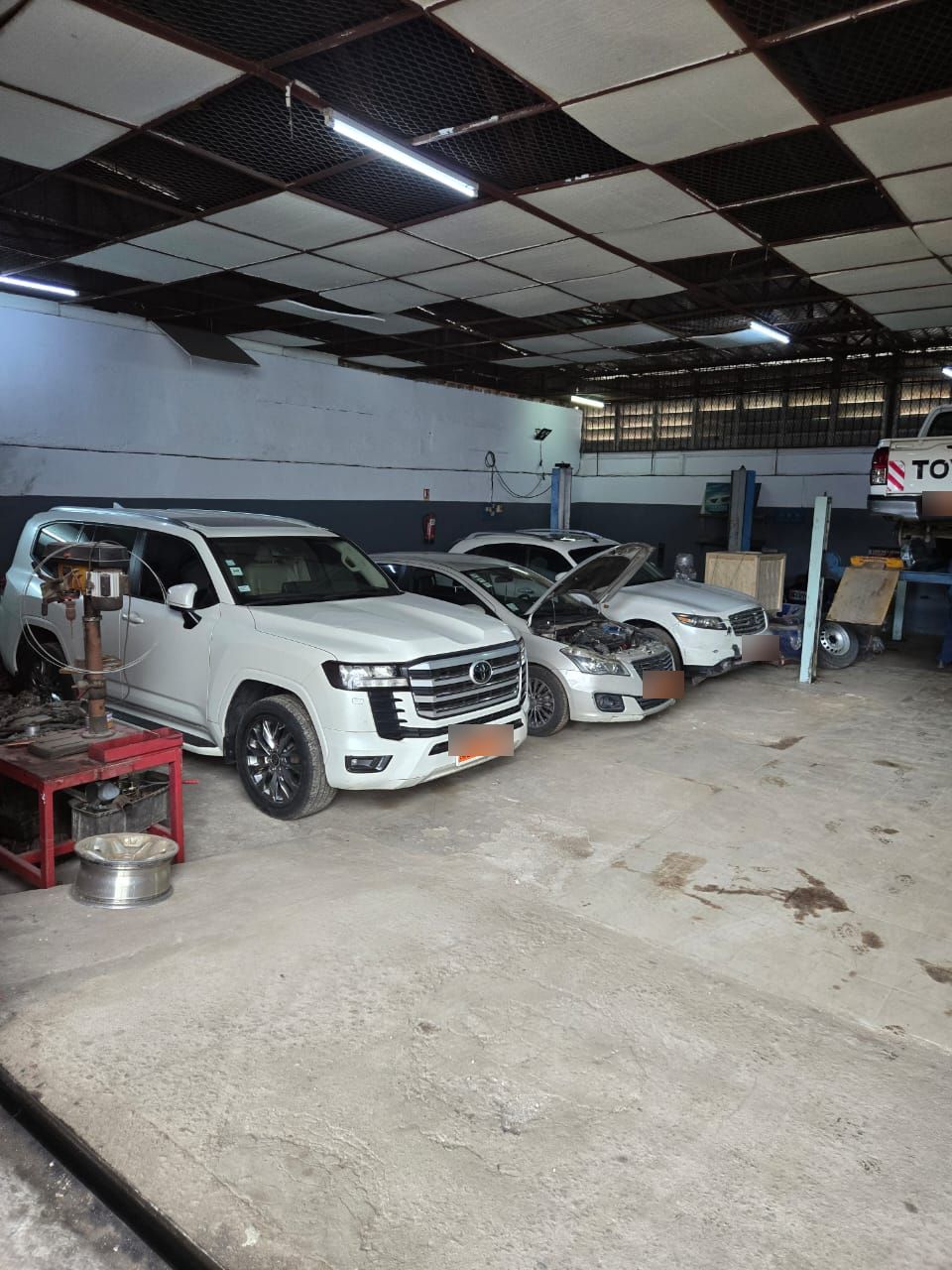 Intérieur de l’atelier : SUV et berlines en cours d’entretien